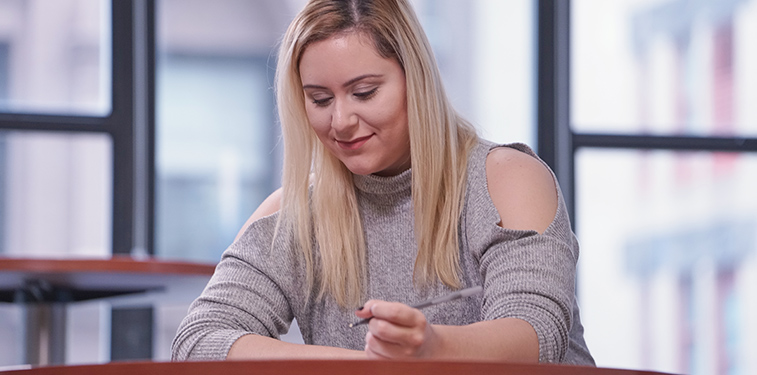 Female student at a desk on campus at CUNY SPS