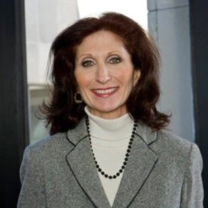 Photo of CUNY SPS Dean Dr. Lisa R. Braverman wearing grey blazer and smiling while standing in front of office windo