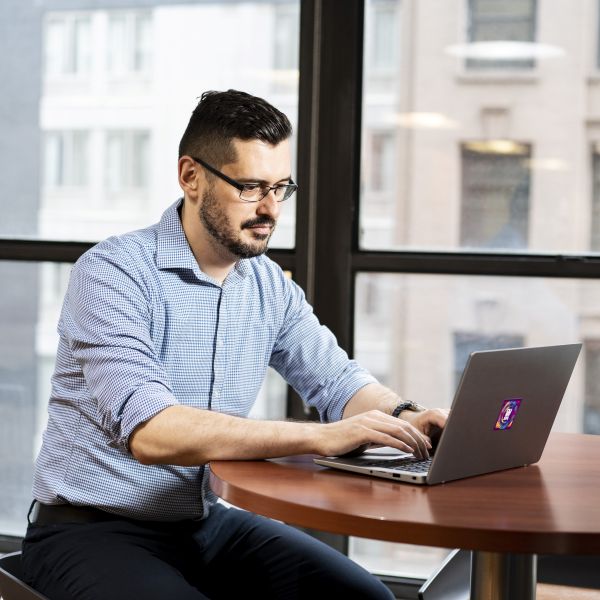 Male CUNY SPS Student Gazes At His Laptop