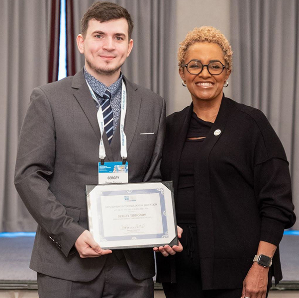 A photo of CUNY SPS Information Science student Sergey Tikhonov, with his award certificate