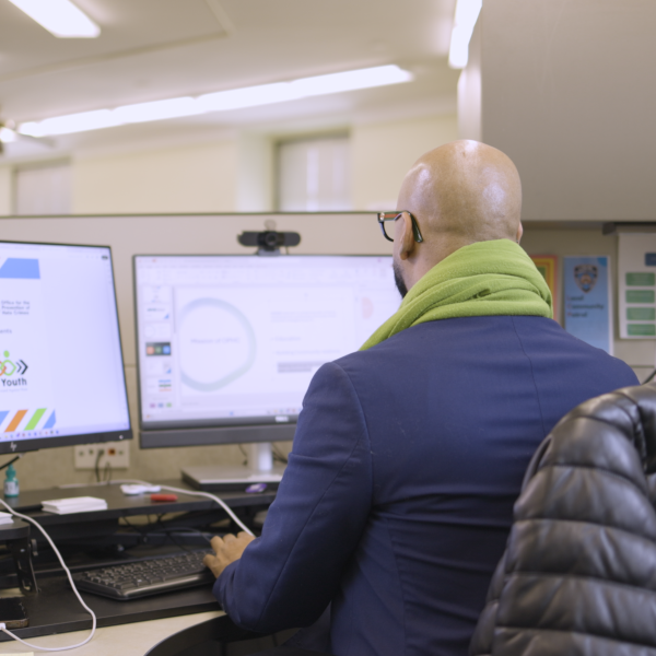 Male CUNY SPS Student Gazes at Two Computer Screens