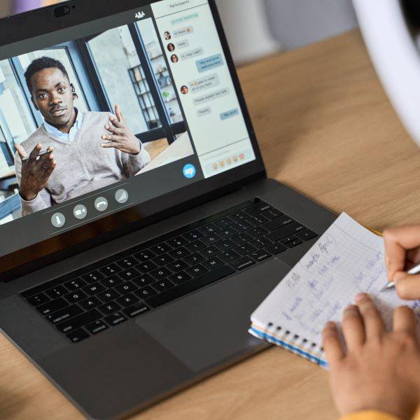 African American student videoconferencing with another student on laptop