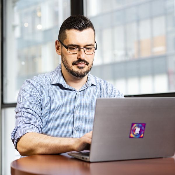 Male CUNY SPS Student Gazes At His Laptop