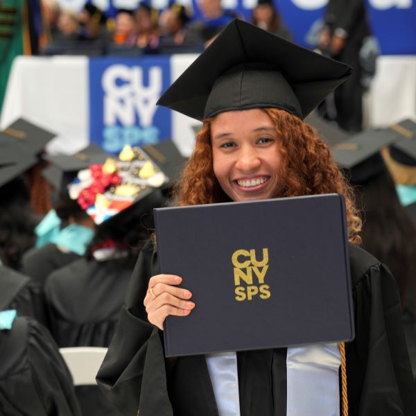 Class of 2023 Graduate Smiles and Poses with her Diploma at CUNY SPS Commencement Ceremony