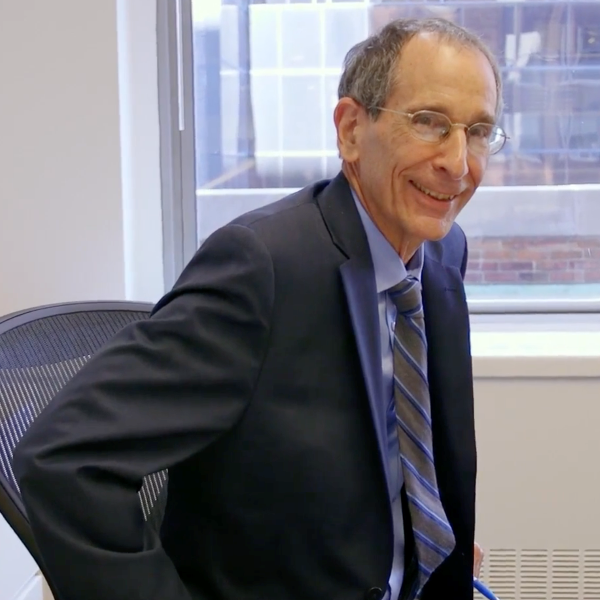 CUNY SPS founding dean John Mogulescu smiling in his office