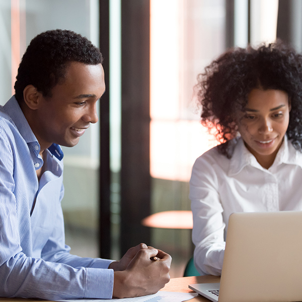 Male and female student working together on laptop