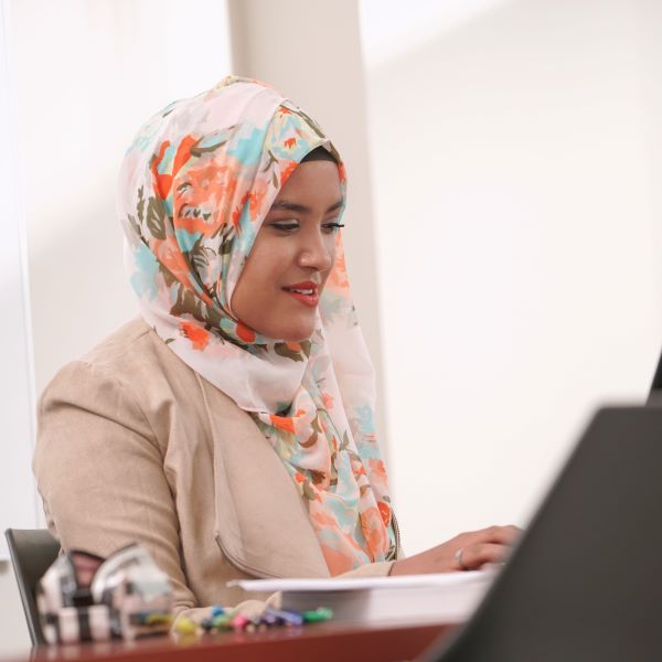 Young woman smiling while looking at desktop computer.