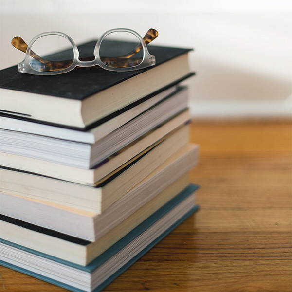 Stack of books and eyeglasses sitting on top