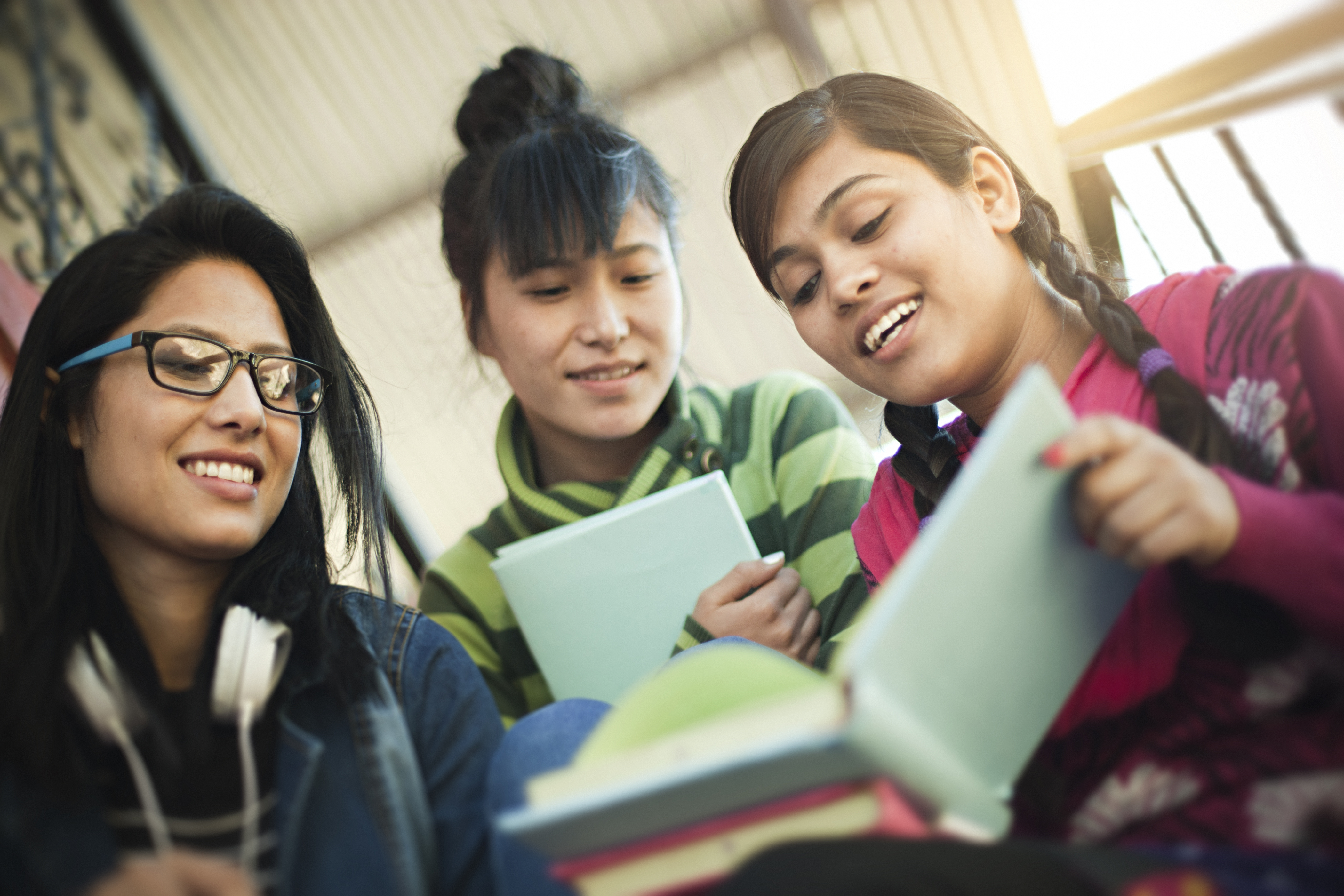 Three girls reading a book