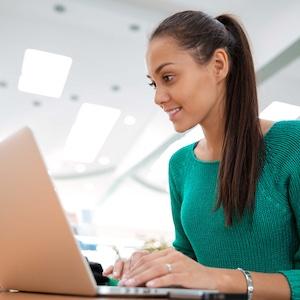 Adult female sitting at a laptop in a computer lab