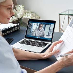 Older Woman discussing resume with a African American Male on a laptop