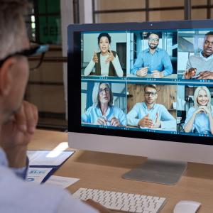 Adult male having discussion with six individuals on a laptop