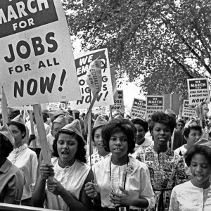 Photo of hundreds of African American women marching in protest with signs about jobs and integrating schools.