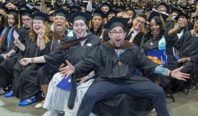 CUNY SPS Class of 2025 Commencement Group of Graduates Waving Hands Toward Camera
