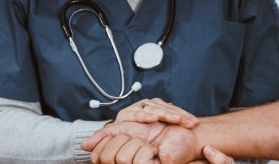Photo of nurse clutching hand of a patient