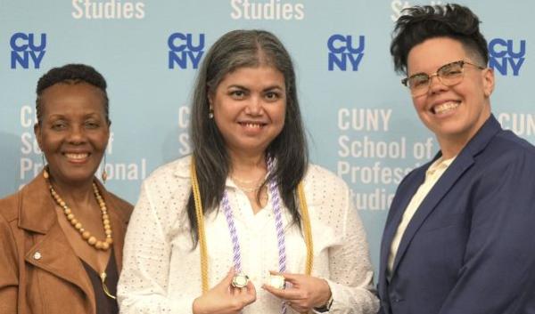 Two female CUNY SPS faculty pose with female graduating nursing student at nursing convocation ceremony