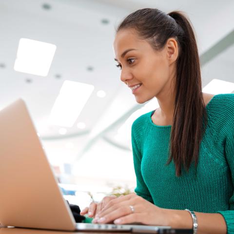 Adult female typing on computer in lab