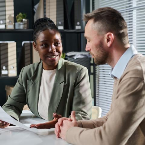 African American Female reviewing resume with Adult American Male