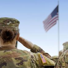 Military woman saluting the American flag