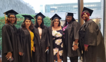 Group of graduates standing together in commencement regalia