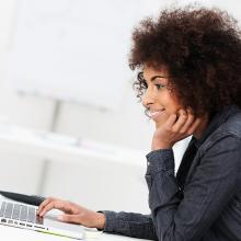African American business woman typing on laptop