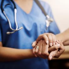 Cropped Shot of a Female Nurse Holding Hands with Patient