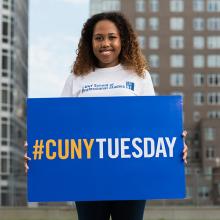 CUNY SPS student holding #CUNYTuesday sign