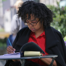 Woman writing in a notebook outside