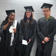 Three graduates of the first CUNY SPS MS HIM class smile and wave before the 2023 Commencement ceremony