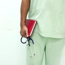 Male nurse in scrubs holding notebook