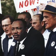 Martin Luther King Jr. standing in crowd during protest