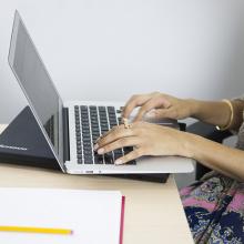 Woman typing on Mac laptop