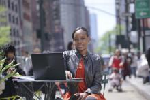 Photo of Tresanne Bonnick sitting outdoors at a table with a laptop