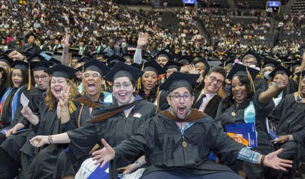 CUNY SPS Class of 2025 Commencement Group of Graduates Waving Hands Toward Camera