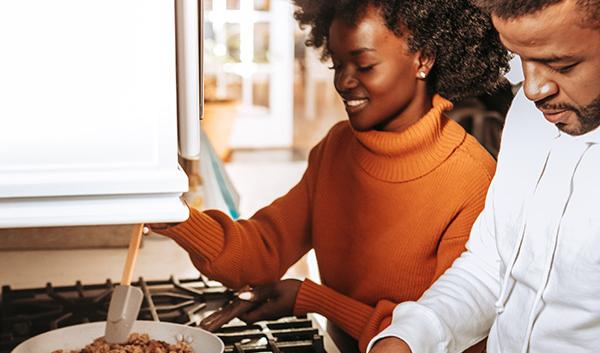 young_african_american_couple_cooking_dinner_in_kitchen